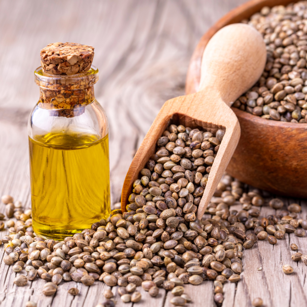 hemp seeds, hemp oil in a wooden bowl and spoon on a wooden worktop
